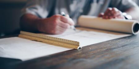 photo of a man drawing out blueprints